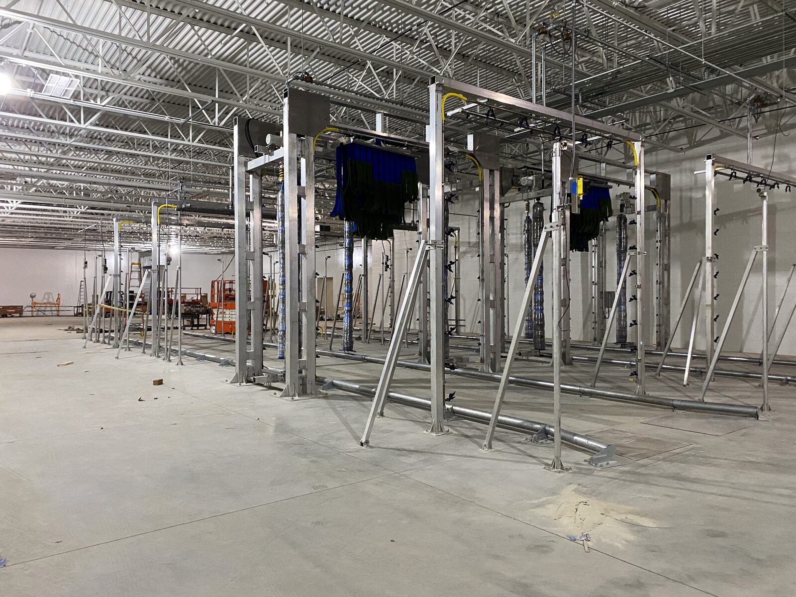 Wash lane gantry systems installed in a fleet wash building